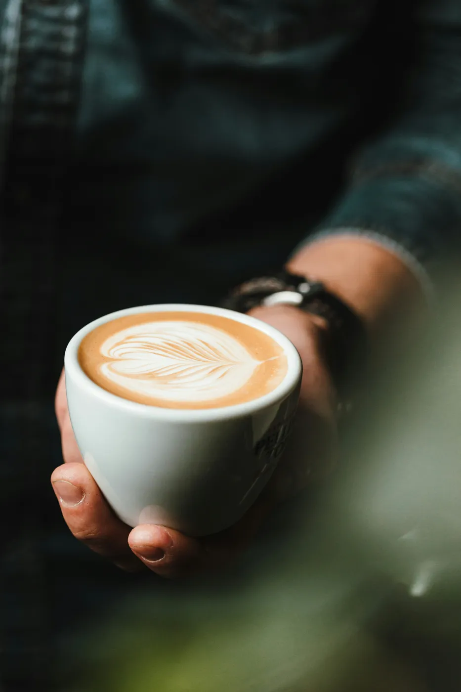 Šálek s latte art v rukou